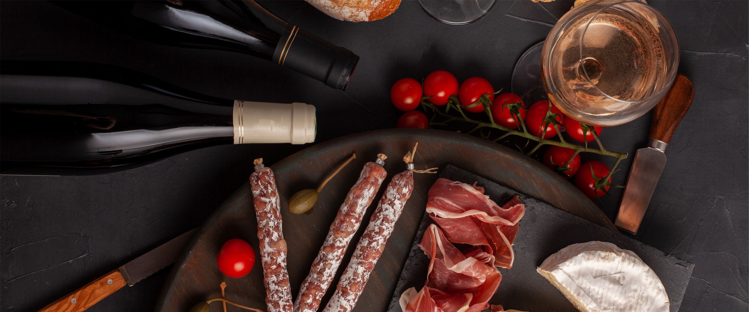 Ansicht auf einen Tisch mit Wein, Fleisch und Käse